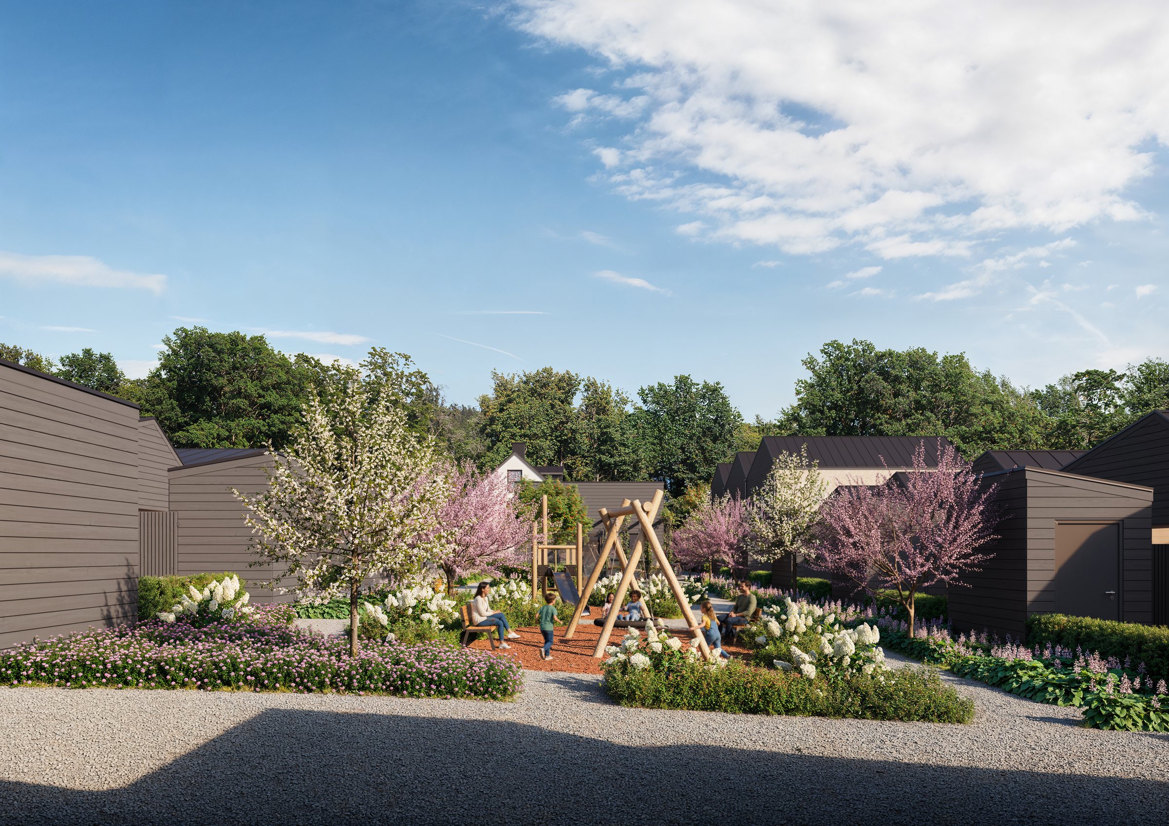 Innergården i dagsljus med lekställning, blomsterplanteringar och gemensamma ytor
